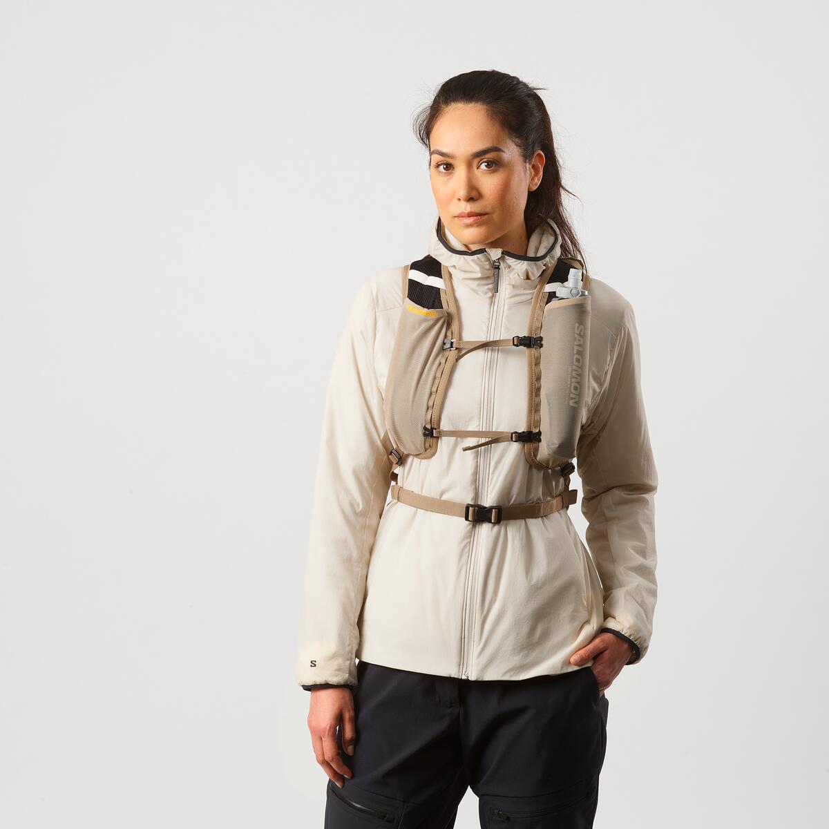Salomon Cross 8 Trailrunning-Rucksack in Beige an einer Frau, Vorderansicht
